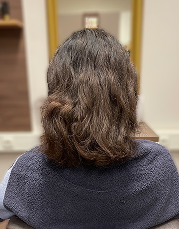 Frisurfoto in Friseursalon, mittel lange braune wellige Haare, Vorherfoto